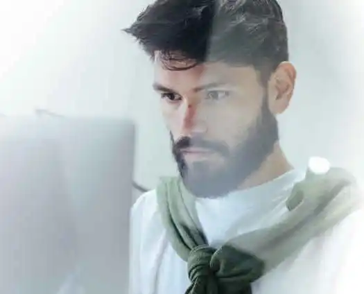 A young man staring intensely at a computer monitor engaged in document translation